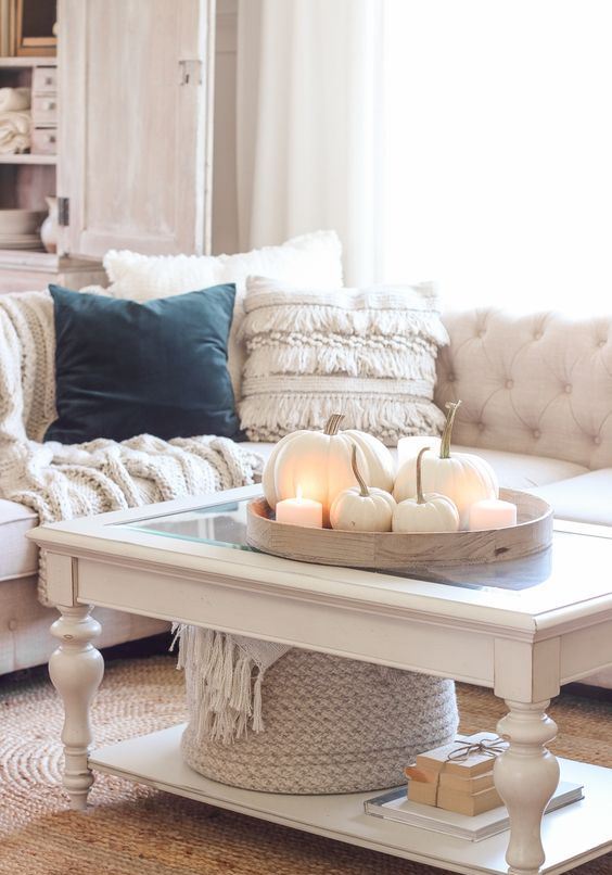 Cozy neutral fall decor   a tray with white pumpkins and pillar candles, a white blanket in a basket