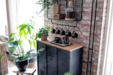 industrial black metal cabinets with a wooden countertop and a wire open shelf on the wall for storage