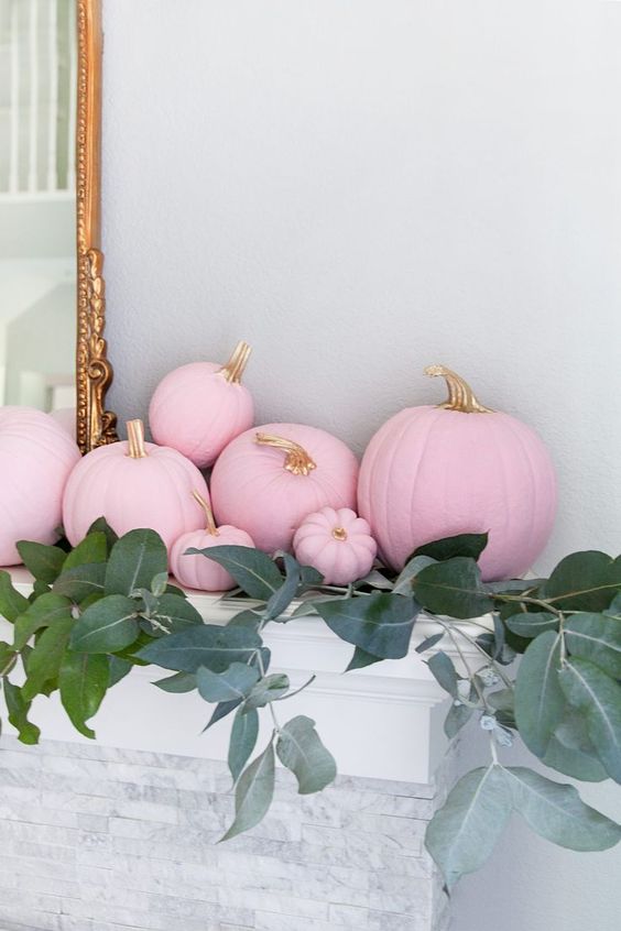 light pink pumpkins with gilded stems and lots of greenery will make the mantel look super glam and fall-like