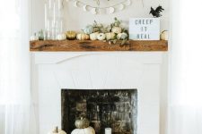 natural Halloween decor with lots of pumpkins, leaves, a garland and some candles is very chic and stylish