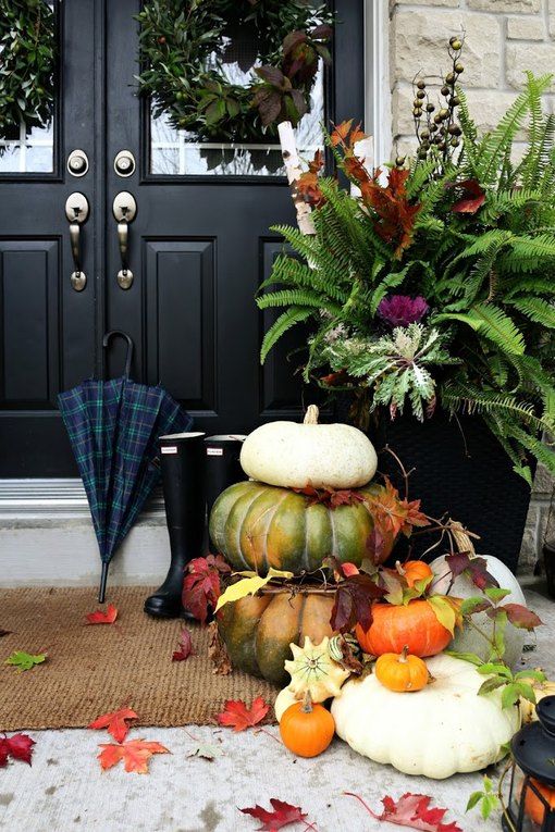 natural outdoor fall decor done with stacked pumpkins and leaves is very stylish and veyr welcoming