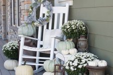 neutral rustic porch decor with white potted blooms, white and neutral pumpkins, white furniture and pillows