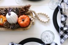 plaid napkins, pumpkin accents and a centerpiece of a dough bowl, pinecones, pumpkins and beads
