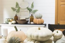 stacks of heirloom pumpkins, candles and greenery in bottles for contemporary dining room decor