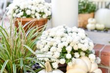 white pumpkins, white potted blooms and acorns make lovely and very natural fall decor for outdoors