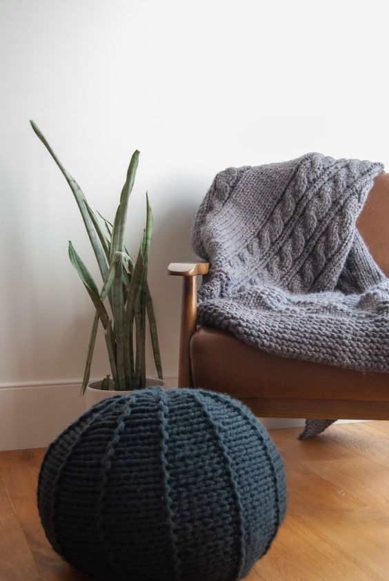 A black knit pouf and a grey knit blanket are a great solution to cozy up your space and make it fall ready