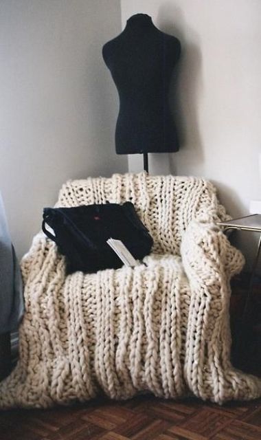 a chair covered with neutral chunky knit is a gorgeous piece to sit on and its imperfect look is very chic