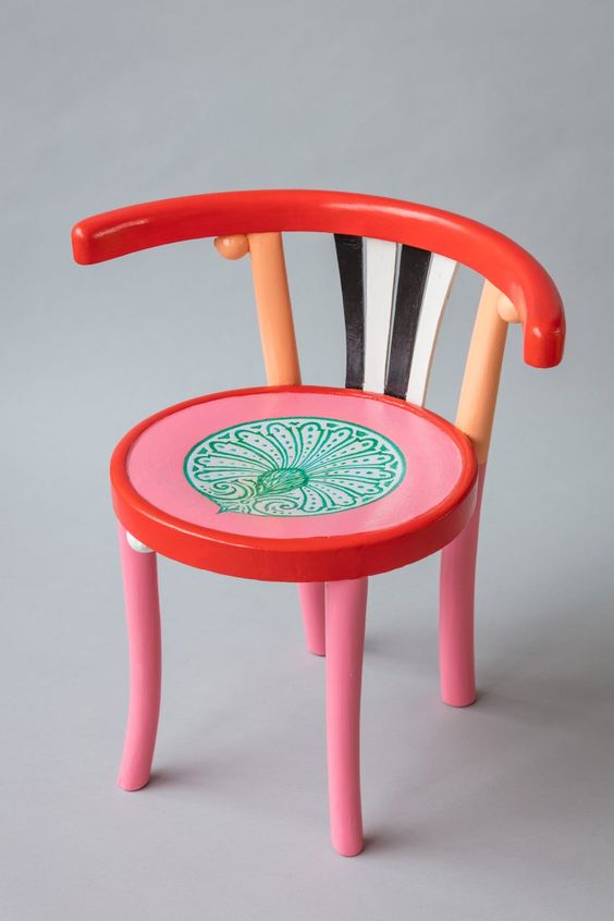 a colorful chair with pink and red seat, with a red back and black and white stripes is a lovely idea for a quirky space