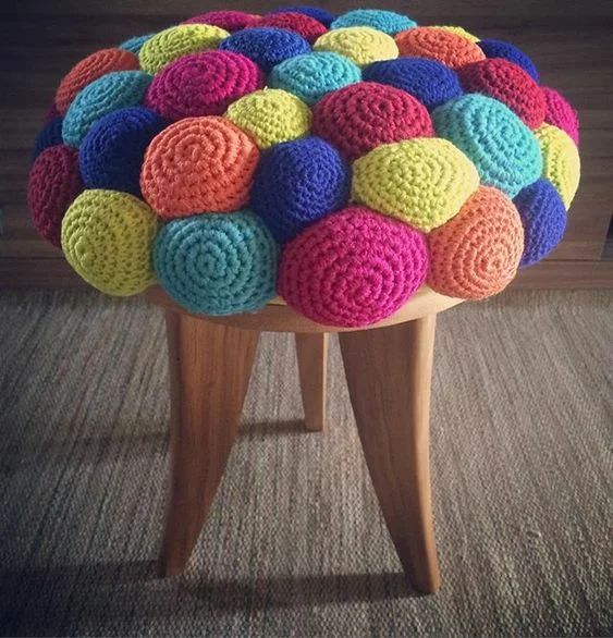 a colorful crochet stool with a ball-like seat is a fun and whimsy idea to rock in your space