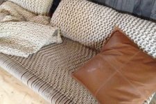 a cool woven bench with knit pillows and a matching blanket is a gorgeous place to have a nap