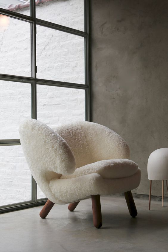 a cute white faux fur chair with a fresh and modern take ona wingback and wooden legs is very welcoming