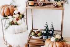 a fall bar cart with heirloom pumpkins stacked, lush fall florals and greenery, pomegranates and greenery