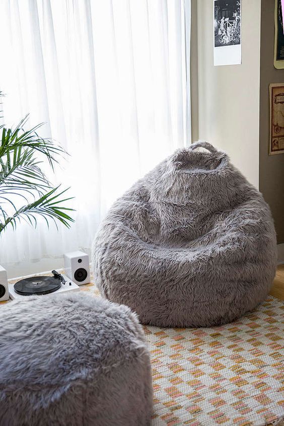 a grey faux fur beanbag chair and an ottoman make up a chic and stylish combo that will cozy up your space