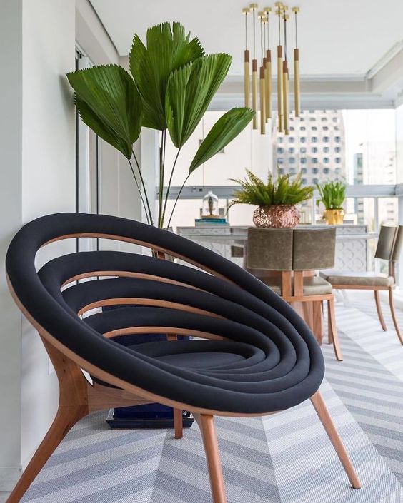 a lovely black and stained wood chair composed of many black upholstered circles is a cool and smart idea
