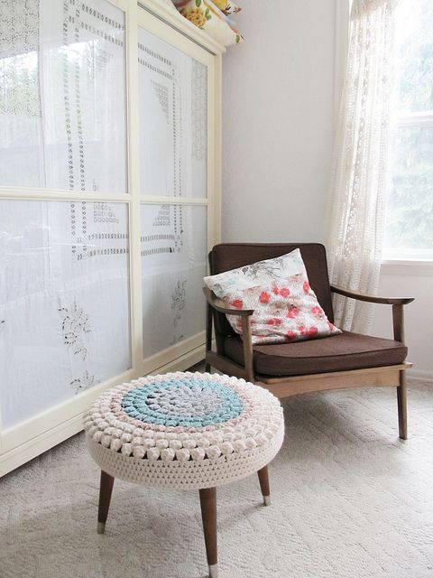 a mid-century modenr ottoman with a pastel crochet cover is a nice idea to add a soft touch of color and coziness