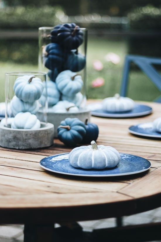 a modern blue fall table setting with light blue and navy pumpkins and plates is lovely