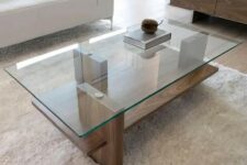 a modern zen coffee table with a wooden base and a glass tabletop, vertical stilts add eye-catchiness