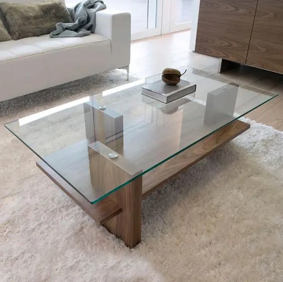 A modern zen coffee table with a wooden base and a glass tabletop, vertical stilts add eye catchiness