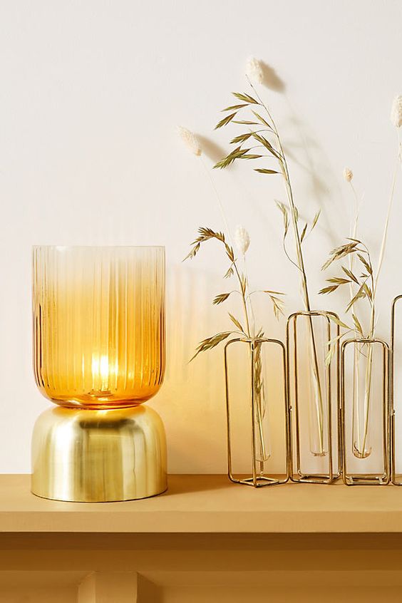 a stylish and elegant gold and tinted glass mug-shaped table lamp is a chic option for a contemporary space