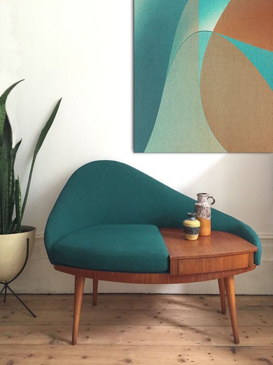 a stylish and functional mid-century modern chair that includes a green seat and back and a stained table with a drawer