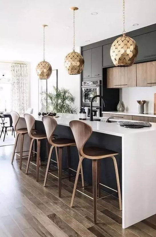 A stylish black and white contemporary kitchen with jaw dropping gold scale pendant lamps is jaw dropping