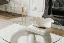 a stylish modern coffee table of arched legs and a round glass tabletop is a cool addition to your living room