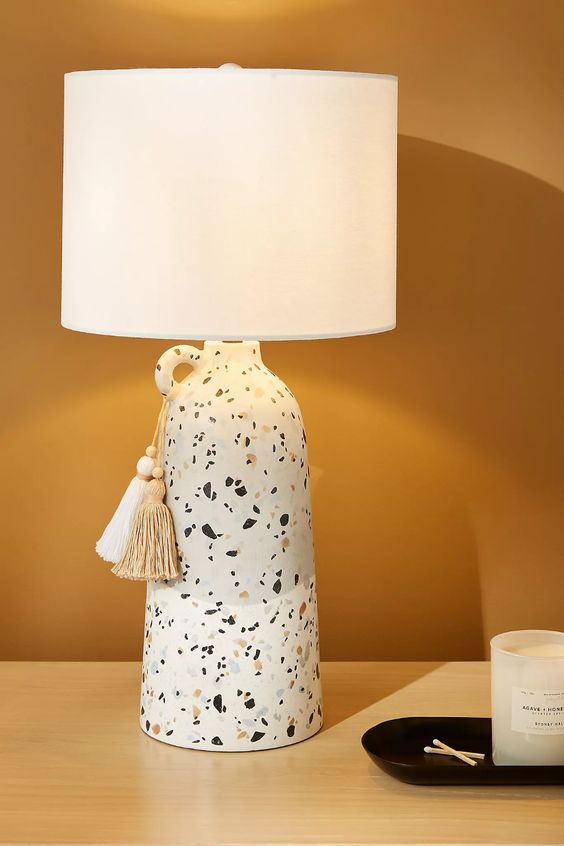a stylish terrazzo vase table lamp with a sleek white lampshade and tassels is a cool accent idea