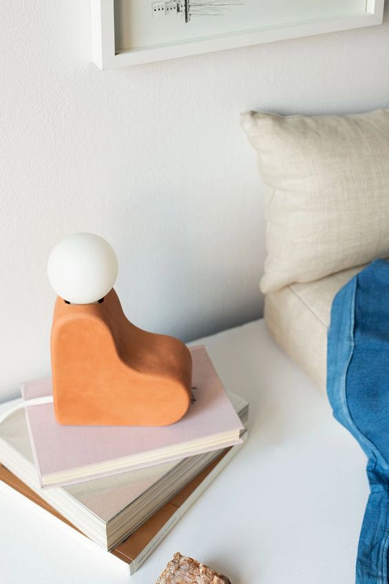 a unique terra cotta heart table lamp with a bulb on top is a creative and fun idea for a mid-century modern space