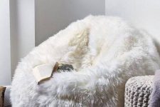 a white faux fur beanbag chair plus some cozy chunky knit stools are welcoming and cozy furniture for any space