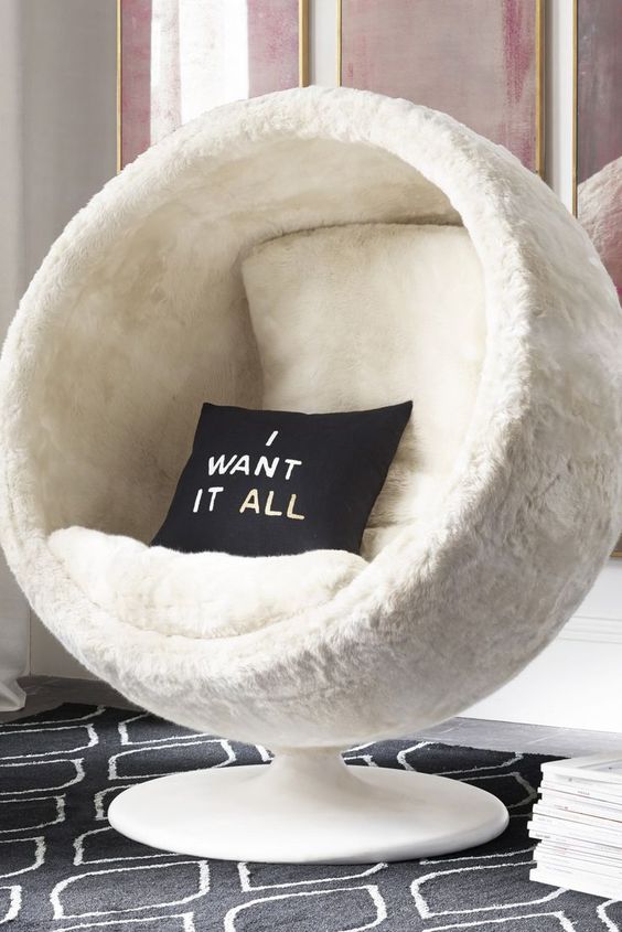 a white faux fur pod chair with cushions and pillows is a fantastic piece to dive in and enjoy comfort and coziness