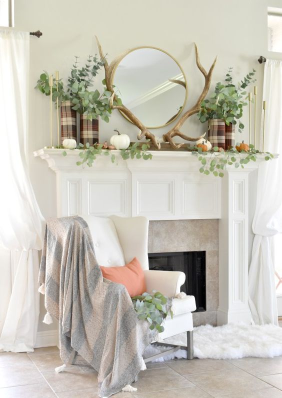 a woodland fall mantel with antlers, natural pumpkins, greenery and plaid vases