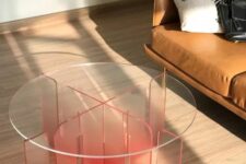 an acrylic coffee table of a semi-sheer red acrylic base and a clear glass tabletop is a bold and fun touch to the space