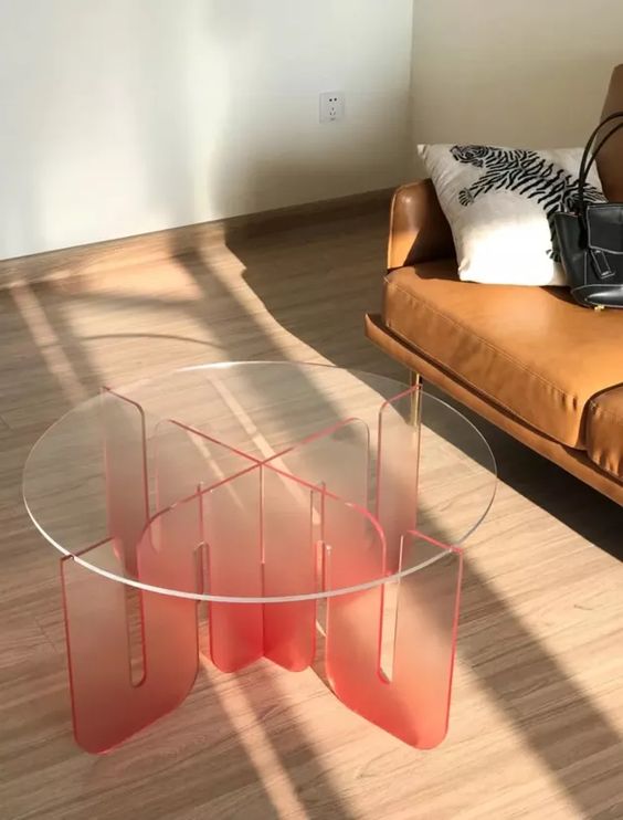 An acrylic coffee table of a semi sheer red acrylic base and a clear glass tabletop is a bold and fun touch to the space