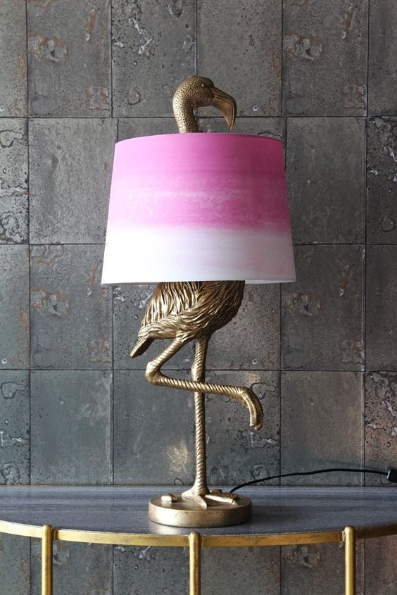 An antique bronze flamingo table lamp with a tie dye pink lampshade for a touch of color to the space