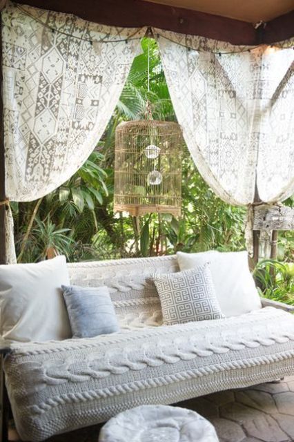 an outdoor sofa covered with a cool crochet patterned piece looks very cozy and very stylish