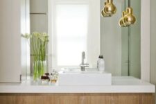 gold shaped pendant lamps accent the bathroom giving it a chic look and a timeless feel as metallics are timeless