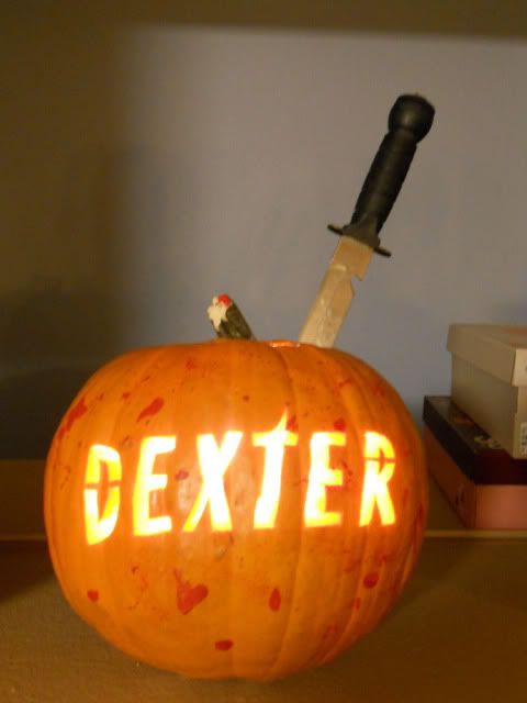 a bold lit up DEXTER pumpkin with blood splatters and a knife is a bold solution for a Dexter-themed party