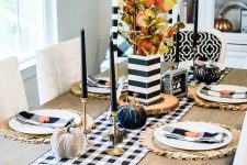a glam black and white Thanksgiving tablescape with a buffalo check runner and napkins, black candles and black and white pumpkins