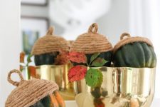 a gold polished bowl with gourds turned into oversized acorns using rope is a stylish and quirky centerpiece to rock for Thanksgiving