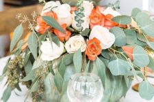 a green pumpkin with blush and coral blooms and greenery is a beautiful Thanksgiving centerpiece to try