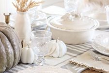 a neutral rustic Thanksgiving tablescape with a striped runner, white and taupe pumpkins, wheat and white porcelain