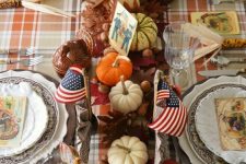 a refined vintage Thanksgiving tablescape with dried leaves, nuts, acorns, pumpkins, vintage porcelain and vintage cards