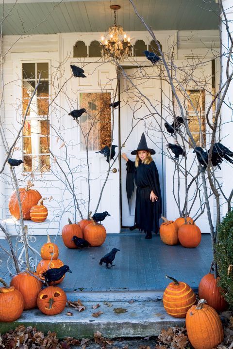 a rustic Halloween porch with orange pumpkins and branches, crows is a stylish fall space
