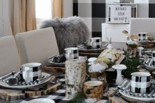 a rustic Thanksgiving tablescape in black and white, with wood slices, buffalo check linens and mugs, greenery