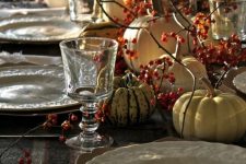 a rustic vintage Thanksgiving tablescape with printed porcelain, berries, natural pumpkins and refined glasses