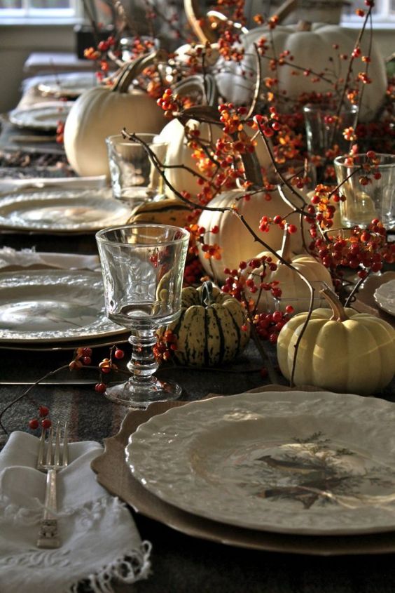 a rustic vintage Thanksgiving tablescape with printed porcelain, berries, natural pumpkins and refined glasses