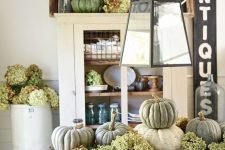 a rustic vintage centerpiece of a crate with green hydrangeas, natural pumpkins is ideal for Thanksgiving