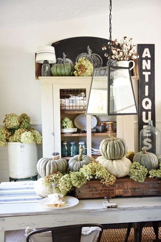 a rustic vintage centerpiece of a crate with green hydrangeas, natural pumpkins is ideal for Thanksgiving