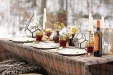 a simple and cozy Thanksgiving tablescape with candles, billy balls in apothecary jars, lanterns and a plaid tablecloth