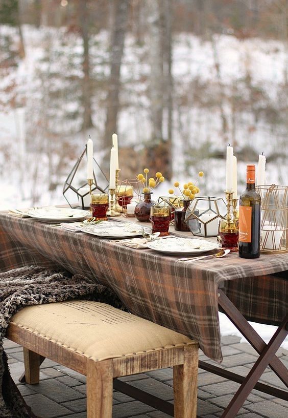 a simple and cozy Thanksgiving tablescape with candles, billy balls in apothecary jars, lanterns and a plaid tablecloth